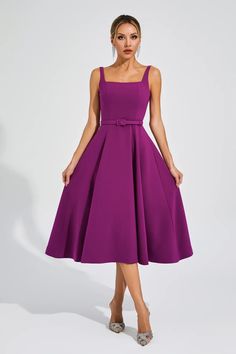 a woman wearing a purple dress and heels