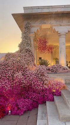 flowers are growing on the steps in front of a building with stairs leading up to it