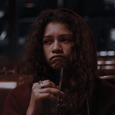 a woman with long hair holding a glass in her hand