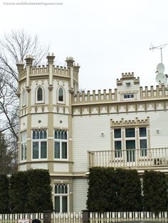 a large white building sitting next to a lush green park