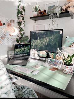 a laptop computer sitting on top of a desk next to a desktop monitor and keyboard