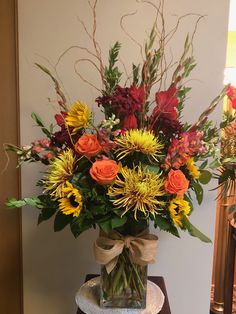 a vase filled with lots of flowers on top of a table