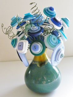 a vase filled with lots of blue and white buttons