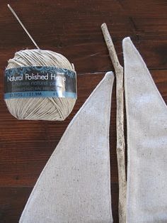 two pieces of white yarn sitting on top of a wooden table next to a pair of scissors