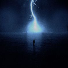 a person standing in the water under a lightning bolt