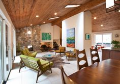 a living room filled with furniture and a fire place next to a dining room table