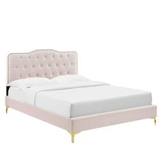 a white bed with gold legs and headboard