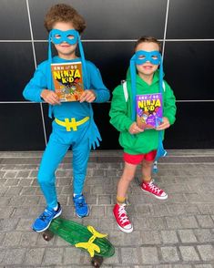 two young boys dressed in costumes standing next to each other with books on their backs