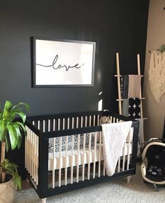 a black and white baby's room with a love sign above the crib