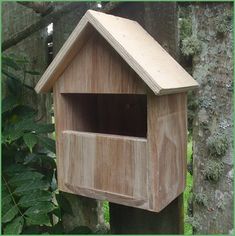 a wooden bird house hanging from a tree