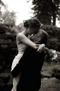 a bride and groom embracing each other in black and white