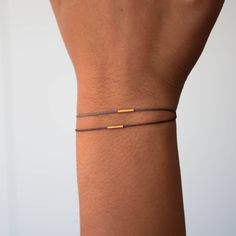 Our minimalistic 18k solid gold balance bracelet will remind you that it is the simple things in life that count. Designed with a 10mm delicately textured tube bead and mounted on a water resistant nylon cord -this will be your best companion this season. Details: 18k solid gold tube bead lightly textured 10mm tube bead nylon cord pure silver end beads Adjustable sliding knot for more great stacking bracelets made of 14k gold please have a look here https://www.etsy.com/shop/VivienFrankDesigns?r Handmade Jewelry Business, 70s Jewelry, Gold Minimalist Jewelry, Balance Bracelet, Couples Bracelets, Tube Bracelet, Jewelry Delicate, Gold Bead Bracelets, Simple Bracelets