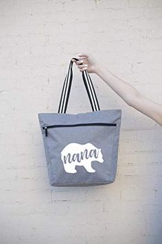 PERFECT GIFT FOR GRANDMA, NANA BEAR: Show your favorite nana bear some love with this cute, fun, unique custom tote bag. Has the fun saying Nana Bear screen printed on the front pocket of the bag. LARGE ZIPPERED TOTE BAG WITH FRONT DEEP ZIPPER POCKET: Dimensions of this bag are 14.5'' X 15'' X 5'' - Has enough room for all of your belongings and more! Includes a zippered main compartment and a zippered front sleeve deep pocket (fits up to an 11” tablet). STURDY CANVAS MATERIAL, FULLY LINED INSID Zippered Tote Bag, Grey Tote Bags, Grey Tote, Bear Graphic, Custom Tote Bags, Zipper Tote Bag, Gift For Grandma, Coach Horse And Carriage Tote, Zippered Tote