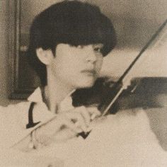 a young man holding a violin in his right hand