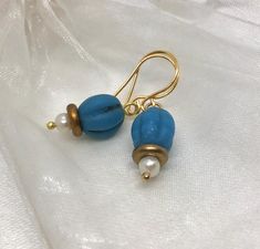 Find joy and everyday fancy with these handmade blue melon glass bead and pearl earrings with gold tone accents.  These earrings present a blend of elegance and polish, showing off your everyday fancy flair. These earrings complement a polished look and can be worn for both casual and more styled  occasions, making them a versatile addition to your jewelry collection.  The lightweight design with handmade ear wires ensures they are easy to wear, preventing any discomfort or strain. Each pair of earrings is packaged in a gift box, ready to be presented as a gift for her or to indulge yourself.  Order your pair today from my woman-owned small business and experience the elegance and grace that these earrings will bring to your collection. Elegant Blue Czech Glass Earrings, Elegant Turquoise Beaded Earrings With Gold Beads, Turquoise Earrings With Gold Beads For Gift, Elegant Turquoise Beaded Earrings For Gift, Elegant Turquoise Earrings With Gold Beads, Elegant Gold Beaded Earrings With Czech Glass, Nickel-free Blue Pearl Earrings Gift, Elegant Czech Glass Jewelry With Gold Beads, Elegant Jewelry With Gold Beads And Czech Glass