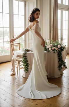 a woman standing in front of a table wearing a wedding dress