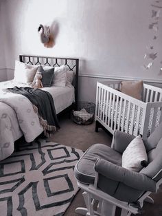 a baby's room with a crib, rocking chair and bed in it