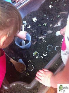 two toddlers are playing in the dirt