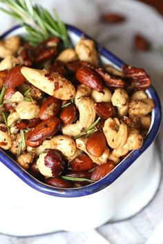 a bowl filled with nuts and rosemary