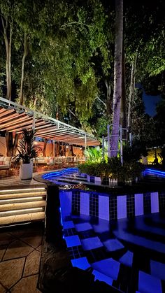 an outdoor swimming pool at night with blue lights