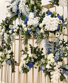 the instagram page on instagram shows an arrangement of white and blue flowers hanging from a gold trellis