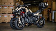 a motorcycle parked inside of a warehouse next to boxes