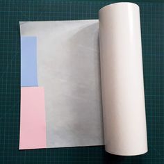 a roll of paper sitting on top of a table next to a rolled up piece of paper