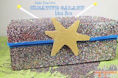 a glittered box with a gold star on it and the words make your own creative galaxy idea box