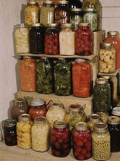 many jars are stacked on top of each other and filled with different types of food