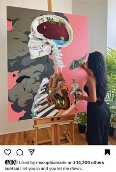 a woman standing in front of a large painting