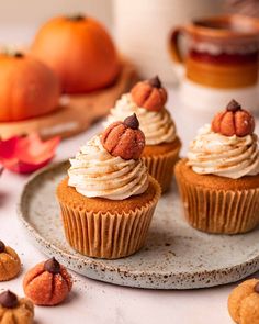 some cupcakes are sitting on a plate next to oranges and other food