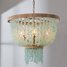 a chandelier hanging from a ceiling with beads on the top and bottom of it