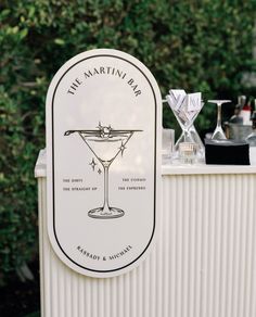 an outdoor bar with drinks on it and two martini glasses sitting on top of it