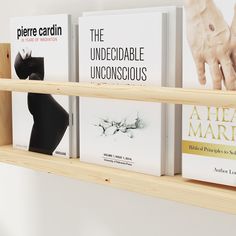 three wooden shelves with books on them