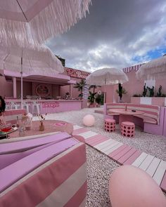 a pink and white striped restaurant with umbrellas