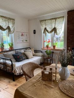 a living room filled with furniture and flowers in vases on top of a table