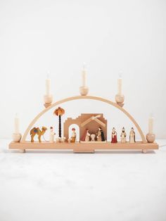 a nativity scene with candles and figurines in the shape of an arch