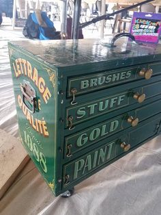 an old green metal box with gold paint on it's sides and the words,