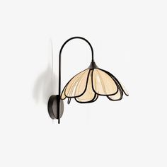 a wall light that is hanging on the side of a wall with a flower shaped glass shade