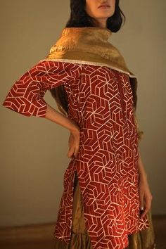 Rust red kurta with gota embroidered motifs and mandarin collar. Paired with handloom tissue antique gold sharara.
Components:2
Embroidered
Neckline:Mandarin
Sleeve Length:Three quarter
Fabric:Gota Chanderi, Handloom Tissue 
Color:Red,Gold
Note: Dupatta worn by the model is not for sale - Aza Fashions Ceremonial Dresses With Mirror Work, Chanderi Kurta With Gold Embroidery Long Sleeve, Ceremonial Red Kurta With Dupatta, Gold Unstitched Shantoon Kurta, Red Sharara With Cutdana For Ceremonial Occasions, Fitted Red Palazzo Set With Mirror Work, Chanderi Long Sleeve Kurta With Gold Embroidery, Fitted Red Palazzo Set With Gota Work, Fitted Red Chanderi Sharara