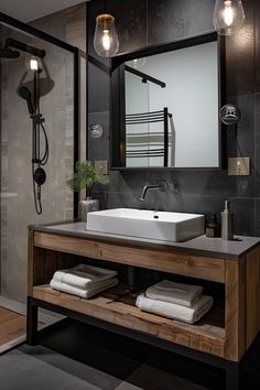 Modern bathroom with a sleek black-framed mirror, a wooden vanity with a white sink, rolled towels, and ambient lighting. Simplistic Bathroom Ideas, Simple Bathroom Ideas Small Budget, Industrial Interior Design Bathroom, Industrial Small Bathroom, Industrial Style Bathroom Ideas, Modern Industrial Bathroom Design, Bad Industrial, Small Square Bathroom, Small Industrial Bathroom