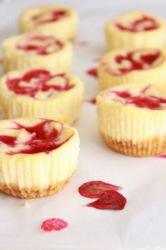 mini cheesecakes with raspberry filling on a white paper towel and rose petals