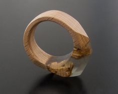 a wood and glass ring sitting on top of a black table next to a wall