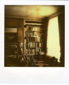 an old photo of a living room with bookshelves