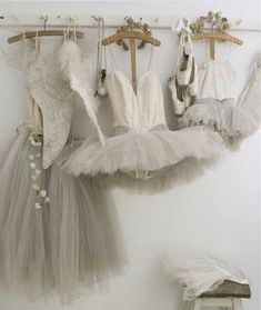 there are several dresses hanging on the clothes rack in this room, and one is wearing a tutu skirt