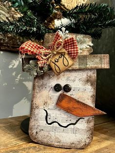 a snowman made out of an old piece of wood with a bow on it