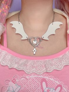 This necklace features a wing design with a heart in the center, separating a pair of wings. The heart is adorned with kitty and cross pendants.  Please note that the price includes only one necklace. Kawaii White Heart-shaped Jewelry, White Heart-shaped Kawaii Jewelry, Wing-shaped Necklace For Valentine's Day Gift, Gothic Heart-shaped Chain Necklace, Harajuku Wings Necklace, Necklace With Cross, Heart-shaped Angel Wings Jewelry Gift, White Wing, Elegant Heart-shaped Angel Wings Necklace