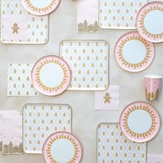 pink and gold plates, napkins, and cups are arranged on a white surface