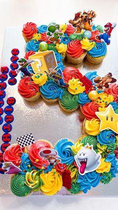 a birthday cake decorated with cupcakes and decorations