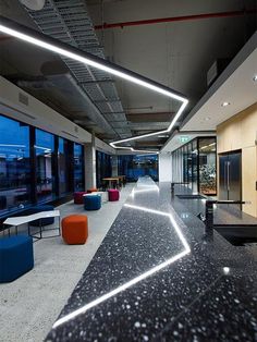 the interior of an office building with black and white marble floors, large windows, and colorful furniture